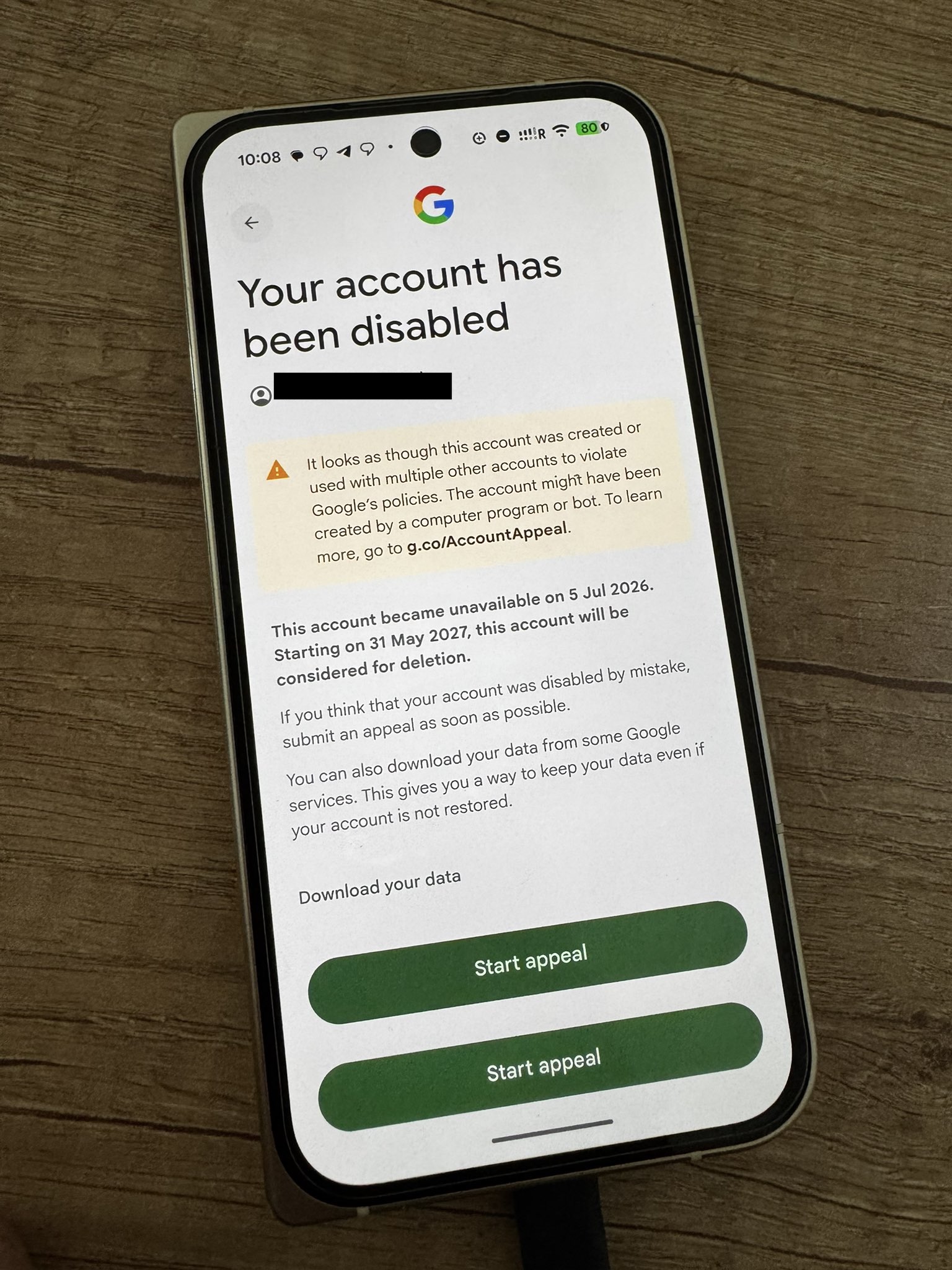 Phone screenshot of Google account disabled page accusing the brand-new account of being created by a computer program or bot